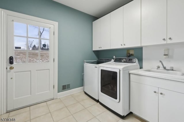 laundry area with cabinet space, a sink, visible vents, and separate washer and dryer