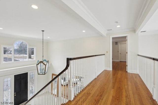 corridor with recessed lighting, ornamental molding, wood finished floors, and an upstairs landing