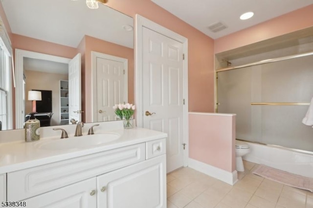 full bathroom featuring toilet, shower / bath combination with glass door, tile patterned flooring, and vanity