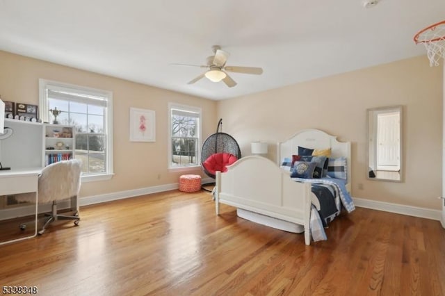 bedroom with light wood-type flooring, ceiling fan, and baseboards