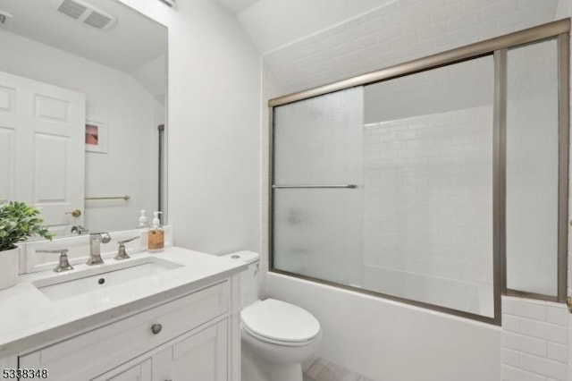 bathroom with toilet, shower / bath combination with glass door, visible vents, and vanity