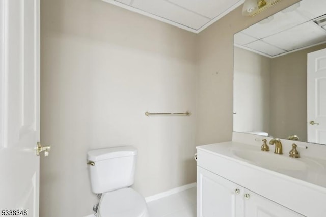 half bath with vanity, toilet, and baseboards