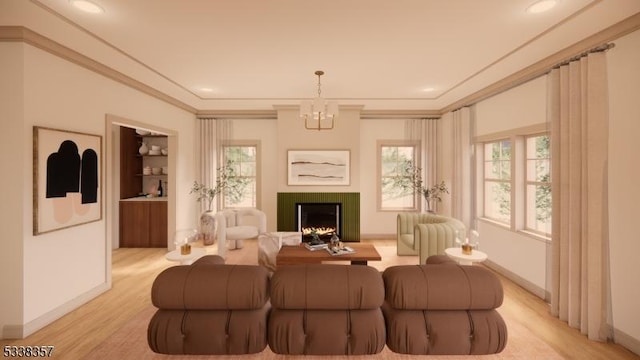 living room featuring crown molding, an inviting chandelier, light wood-style floors, a tile fireplace, and baseboards