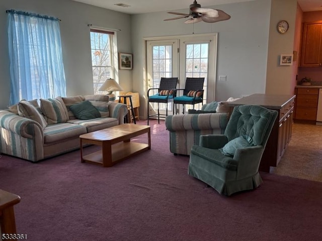 carpeted living room with ceiling fan