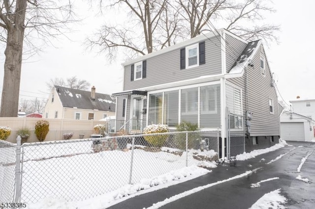 view of front of house featuring a garage and an outbuilding