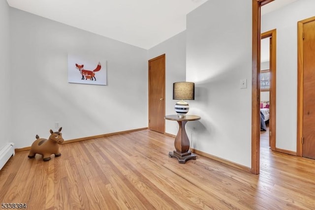 exercise room with wood finished floors and baseboards