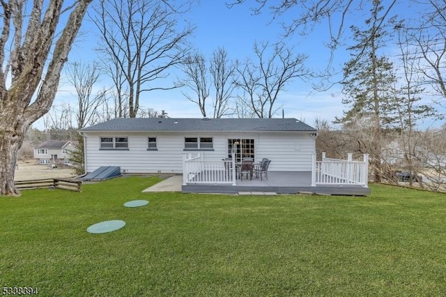 back of house featuring a lawn and a wooden deck