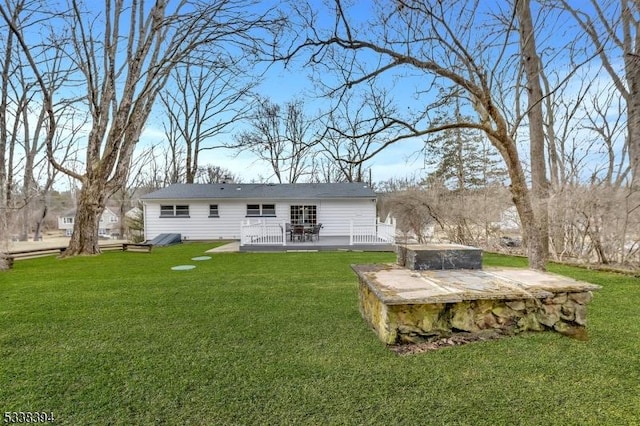 back of property featuring a deck and a lawn