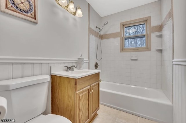 full bath featuring bathing tub / shower combination, toilet, wainscoting, tile patterned flooring, and vanity