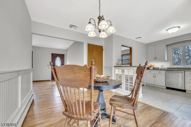 dining space with light wood-type flooring, visible vents, a notable chandelier, and baseboard heating