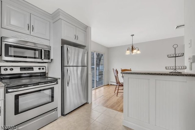 kitchen featuring a chandelier, stainless steel appliances, hanging light fixtures, baseboard heating, and dark stone counters