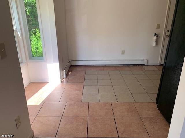 unfurnished room with tile patterned floors and a baseboard heating unit