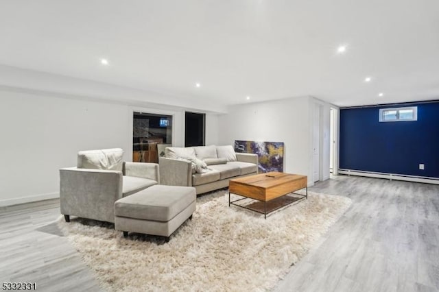 living room with a baseboard radiator and light hardwood / wood-style flooring