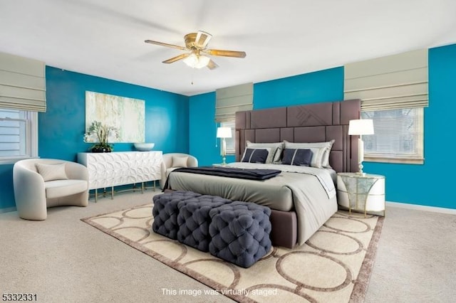 carpeted bedroom with multiple windows and ceiling fan