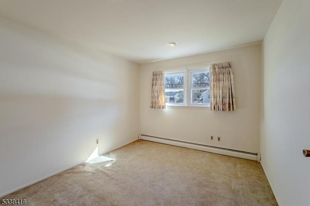 carpeted spare room featuring a baseboard heating unit