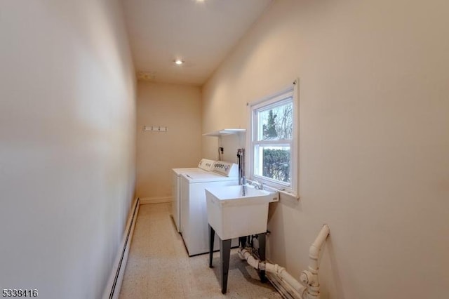 clothes washing area with sink, washer and clothes dryer, and baseboard heating