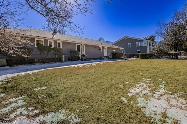 rear view of house featuring a yard and central AC unit