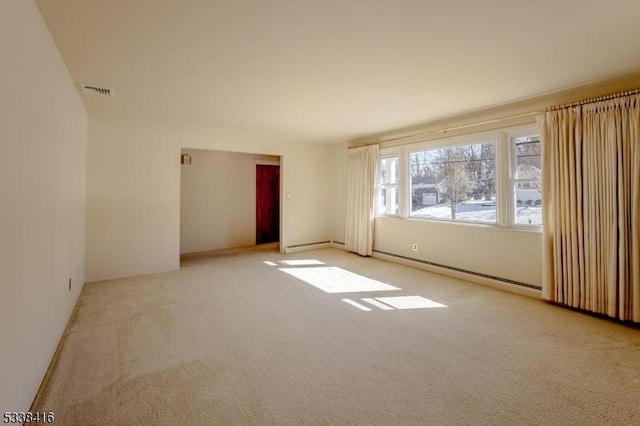 unfurnished room with a baseboard radiator and light carpet