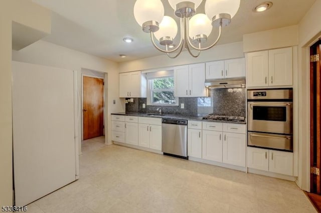 kitchen with sink, backsplash, stainless steel appliances, white cabinets, and a chandelier