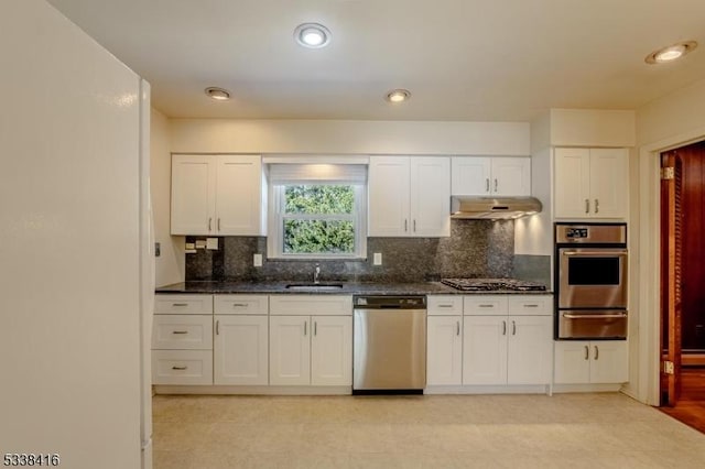 kitchen with white cabinetry, stainless steel appliances, sink, and backsplash