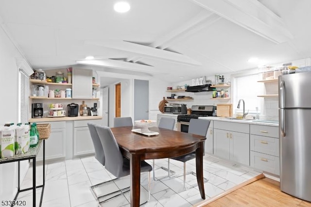 dining room with vaulted ceiling with beams and sink