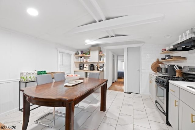 dining space with lofted ceiling with beams