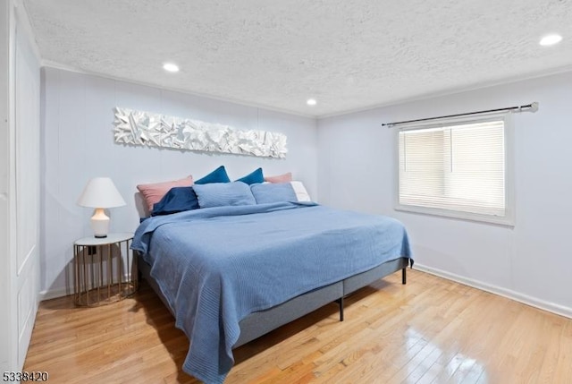 bedroom with wood-type flooring and a textured ceiling