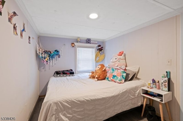 bedroom with ornamental molding and hardwood / wood-style flooring