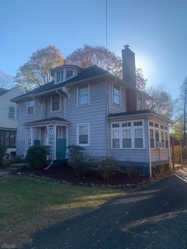 view of front of property with a front lawn and a sunroom