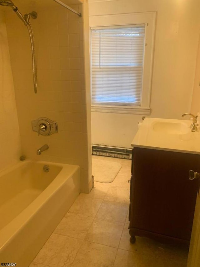 bathroom featuring vanity, tiled shower / bath, and baseboard heating