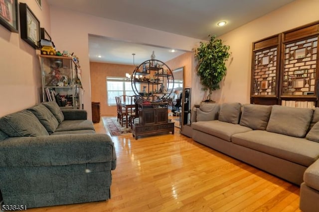 living area featuring recessed lighting, wood finished floors, and an inviting chandelier