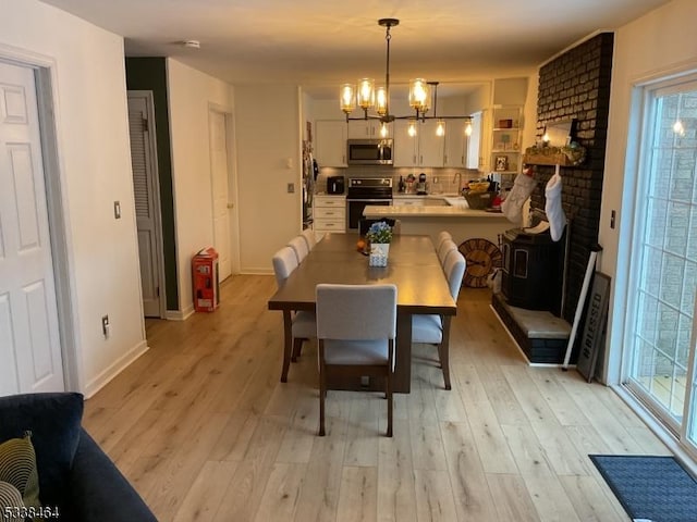 dining area featuring a wealth of natural light, an inviting chandelier, and light hardwood / wood-style floors