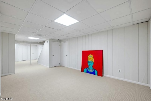 basement with light colored carpet and a drop ceiling