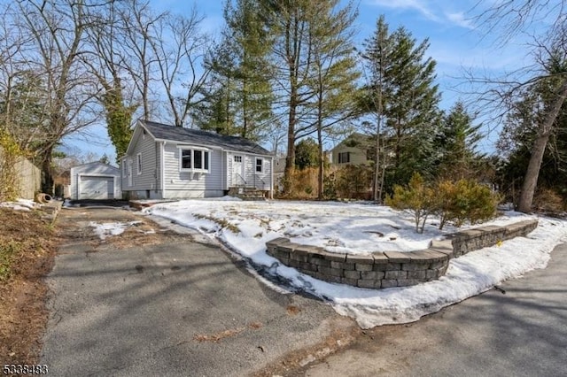 view of front of house featuring a garage, an outbuilding, and driveway