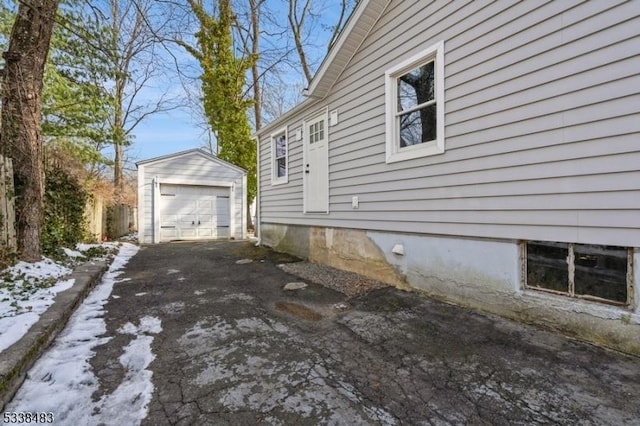 view of side of home with a garage, driveway, and an outbuilding