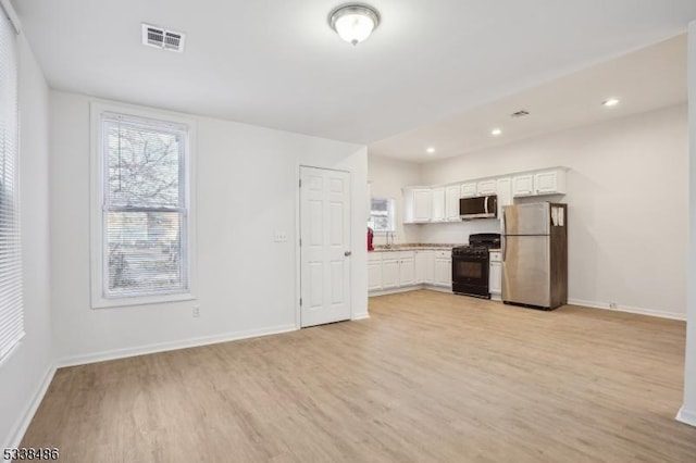 kitchen with white cabinetry, appliances with stainless steel finishes, and light hardwood / wood-style flooring