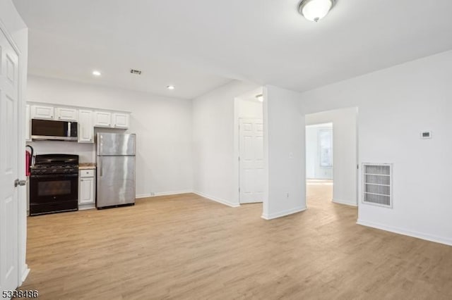 kitchen featuring light wood-type flooring, stainless steel appliances, and white cabinetry