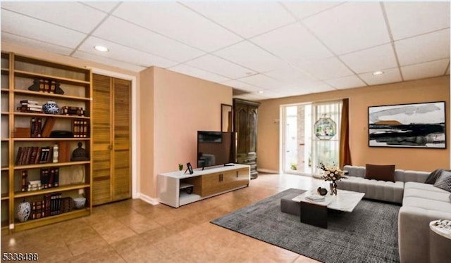 living room with recessed lighting, a drop ceiling, and baseboards