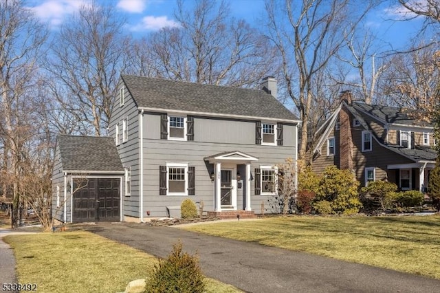 colonial inspired home featuring a garage and a front yard