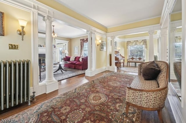 interior space with radiator, ornate columns, crown molding, and dark hardwood / wood-style flooring