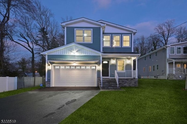 view of front of house featuring a lawn, covered porch, and a garage