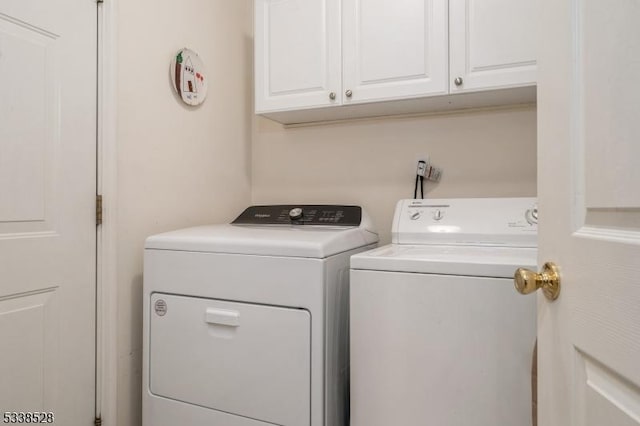 washroom featuring washing machine and dryer and cabinet space