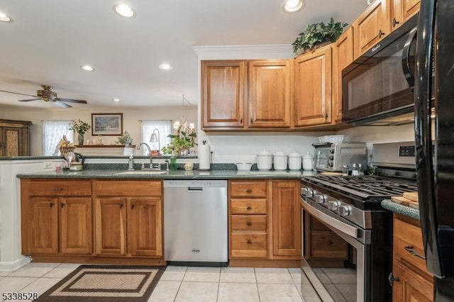 kitchen with light tile patterned floors, dark countertops, brown cabinets, black appliances, and a sink