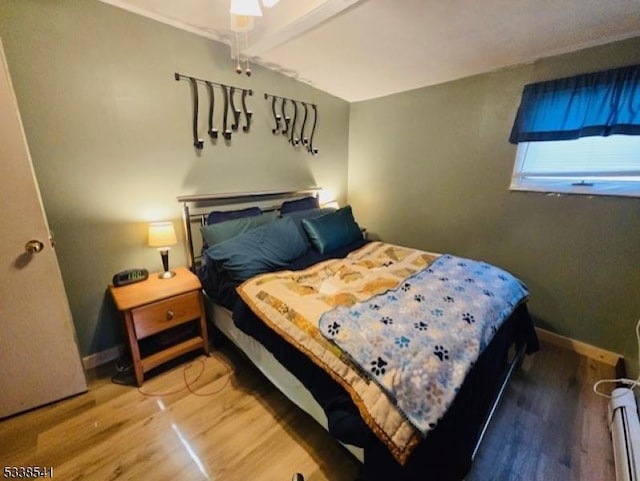 bedroom featuring lofted ceiling with beams and hardwood / wood-style floors