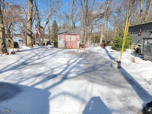 yard covered in snow featuring a storage shed