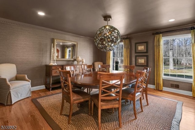 dining room with ornamental molding, a chandelier, and wood-type flooring