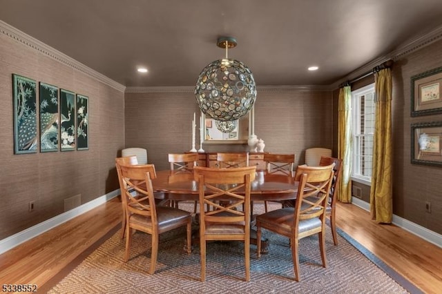 dining space with light wood-type flooring and crown molding