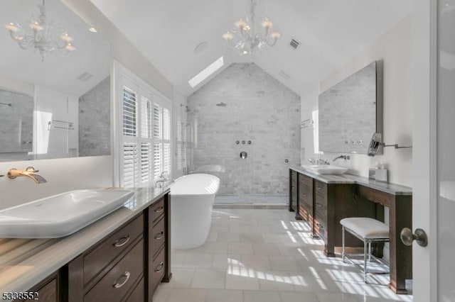 bathroom featuring a washtub, an inviting chandelier, tile walls, vaulted ceiling, and vanity