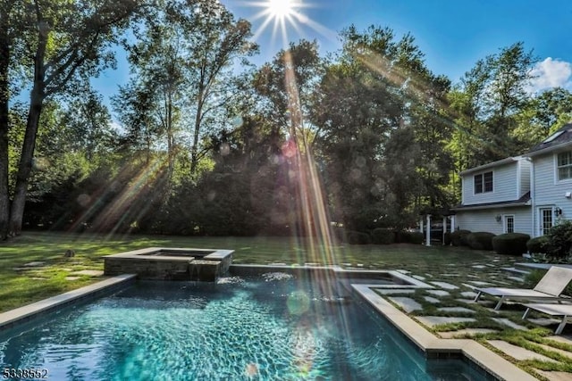 view of swimming pool with an in ground hot tub