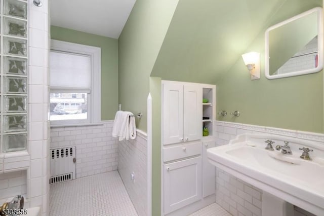 bathroom featuring wainscoting, tile patterned floors, tile walls, and radiator